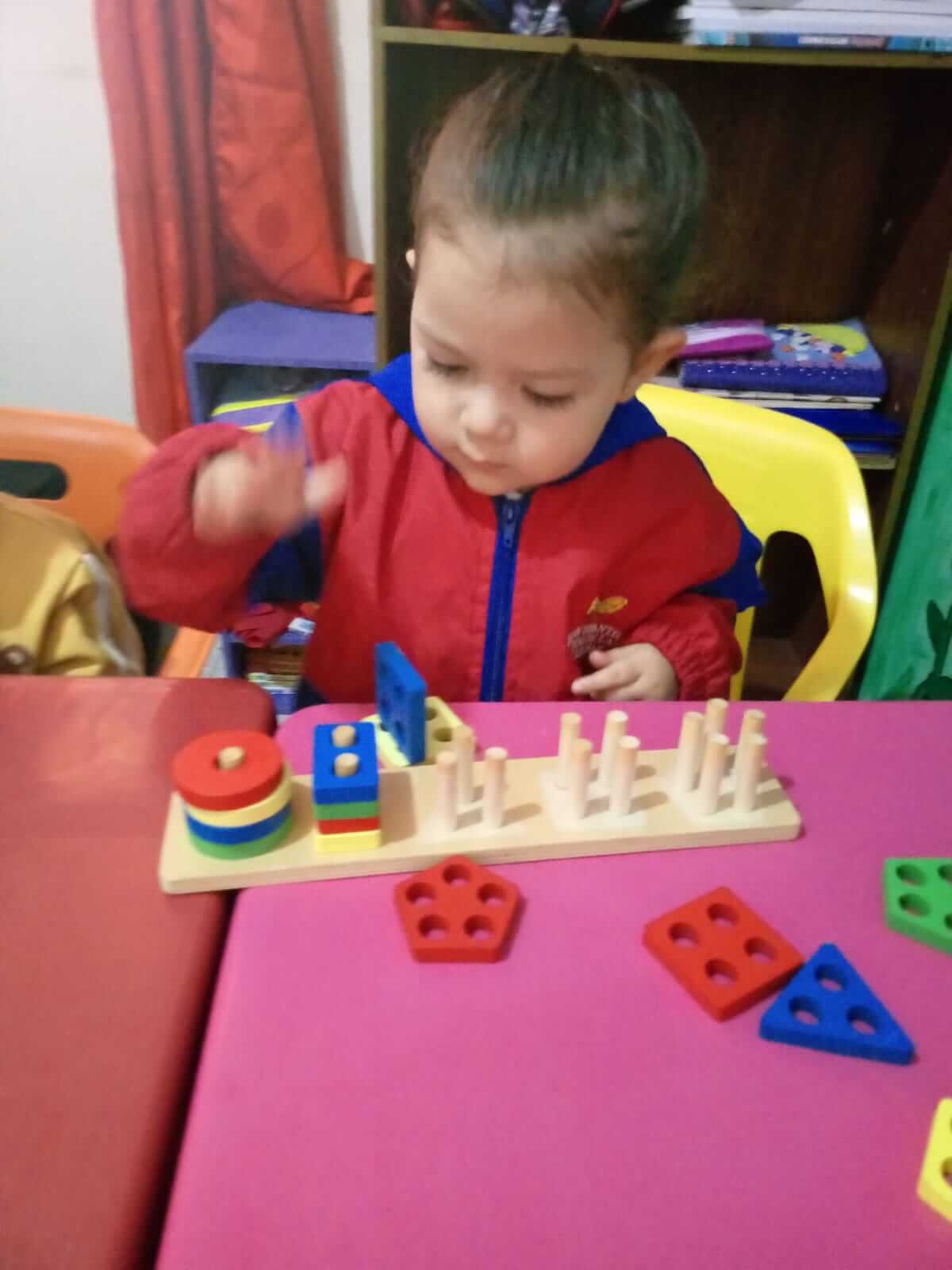 Niña jugando con un rompecabezas de madera Montessori.