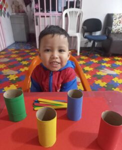 Alumno sonriente durante actividad Montessori con materiales de clasificación coloridos